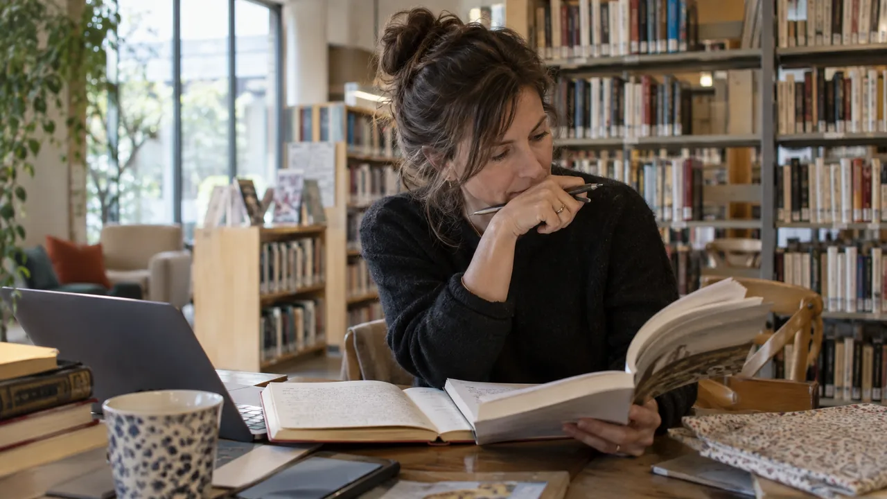 Autrice préparant une rencontre en bibliothèque avec des carnets et son livre