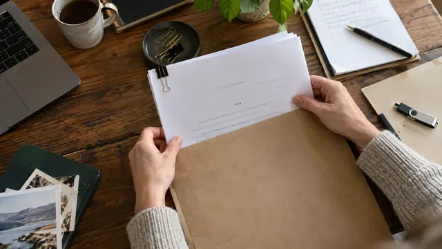Pages de manuscrit, enveloppe et support de stockage sur une table