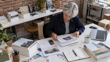 Autrice examinant une maquette de livre et des documents éditoriaux