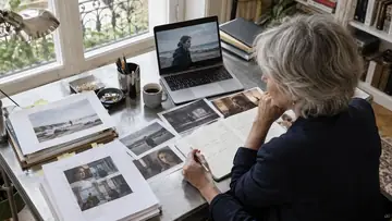 Autrice comparant des documents et des références visuelles de projet