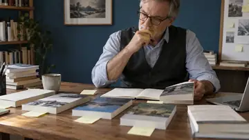 Auteur comparant les livres d’une collection et ses notes